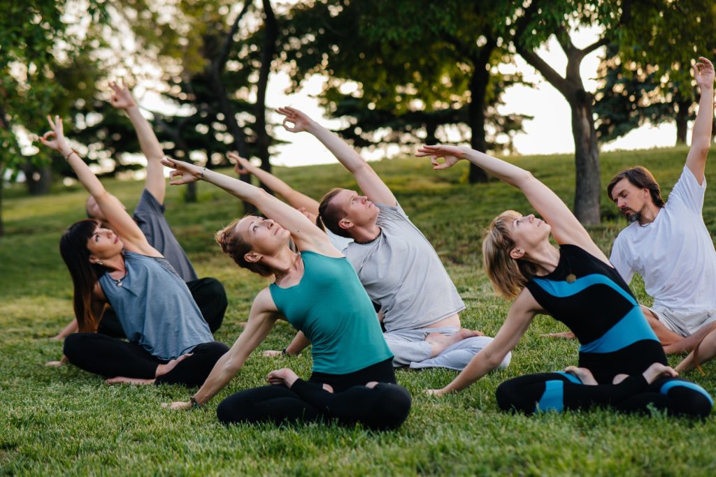 Un groupe de personnes faisant du yoga dans le parc